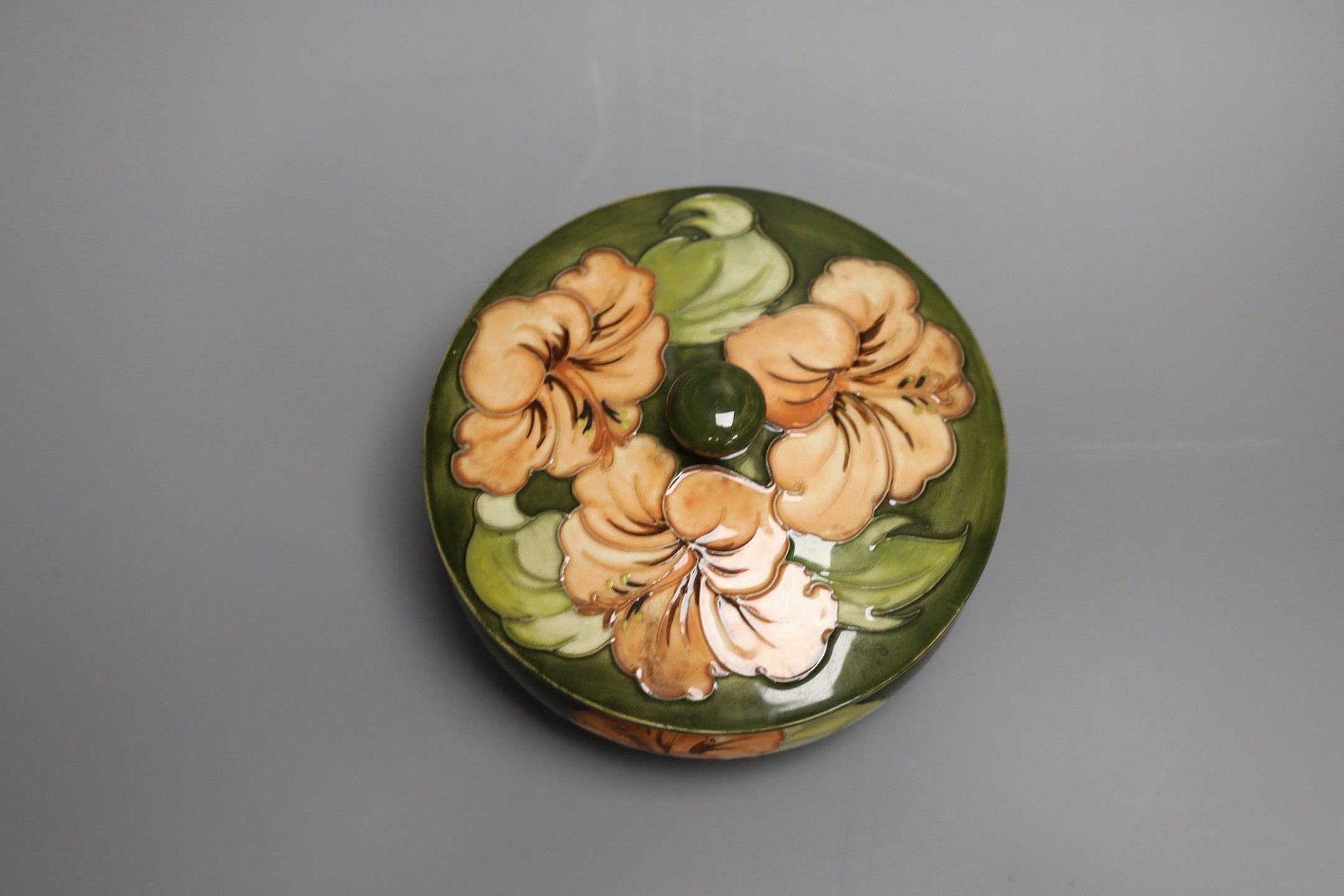 A Moorcroft hibiscus pattern powder bowl and cover, 15cm diam.